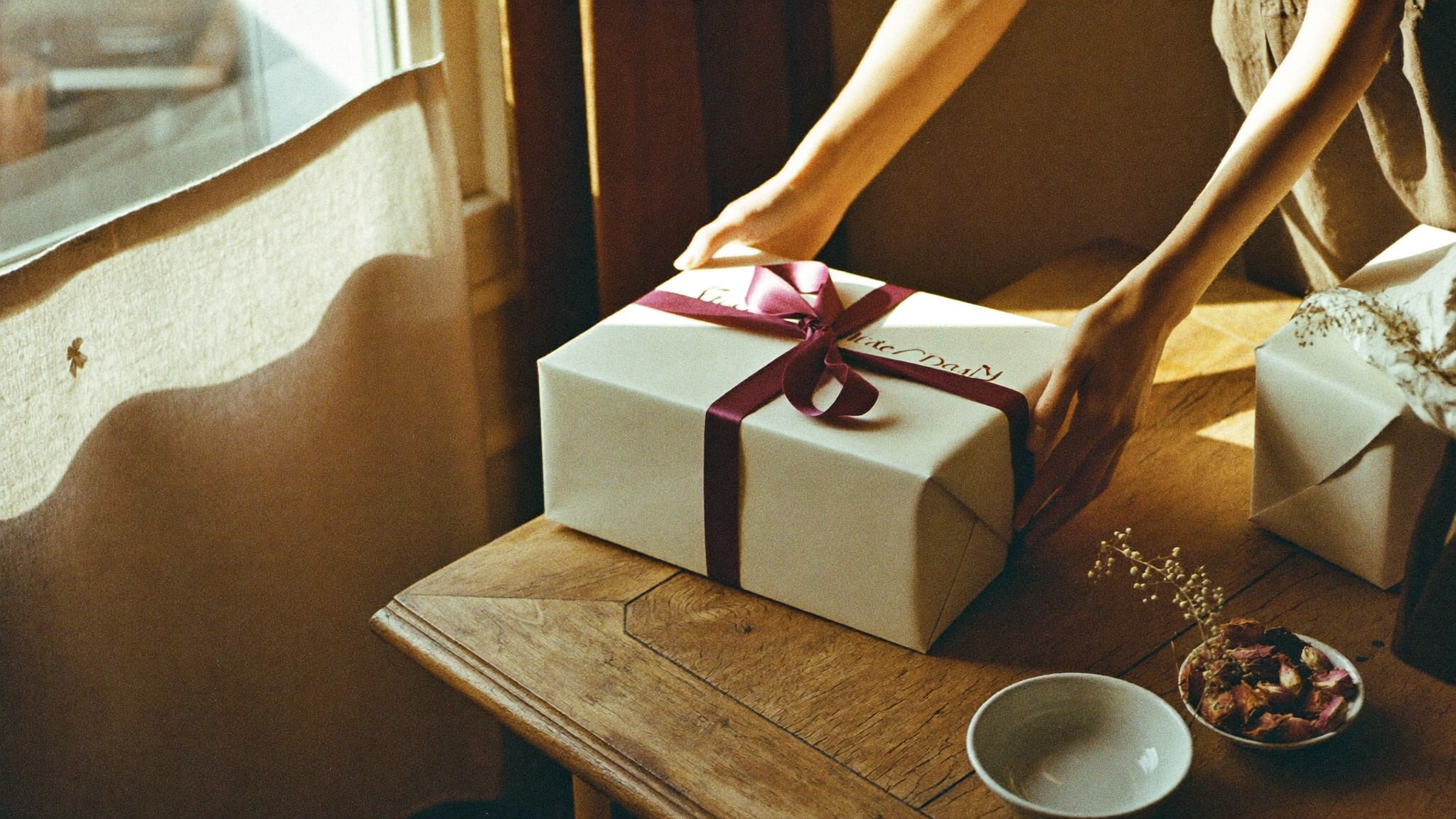 A gift being placed on a table, warm light